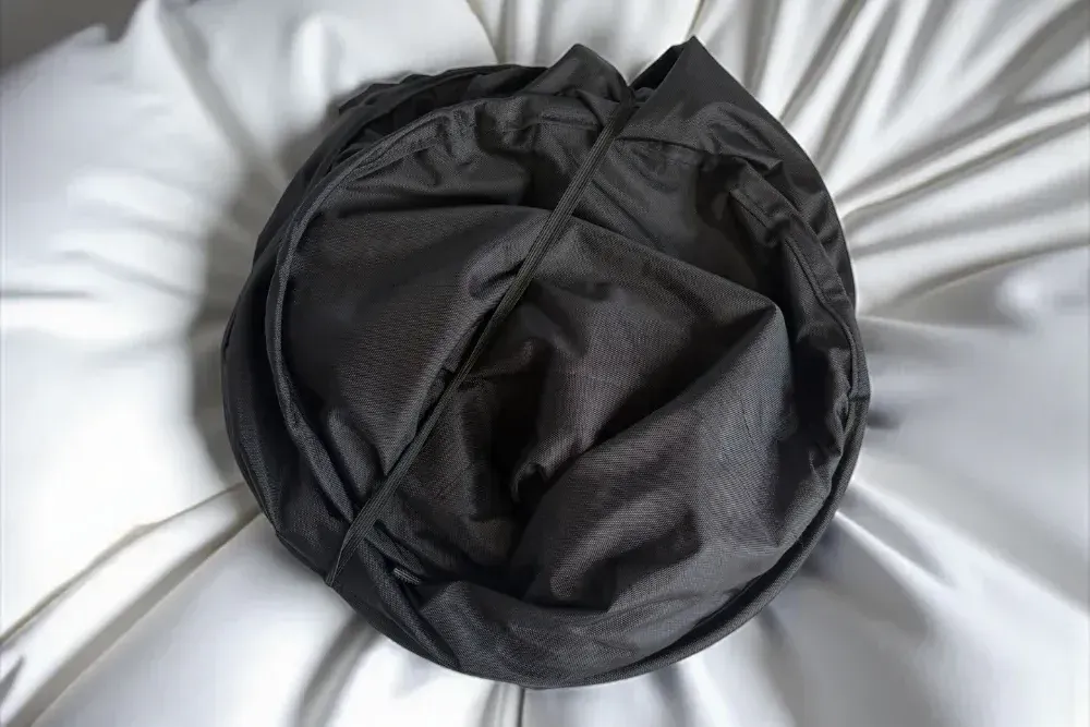 Travel Fanatics Collapsible Laundry Basket folded flat, showing its compact design for easy storage in small spaces like RVs or dorm rooms.