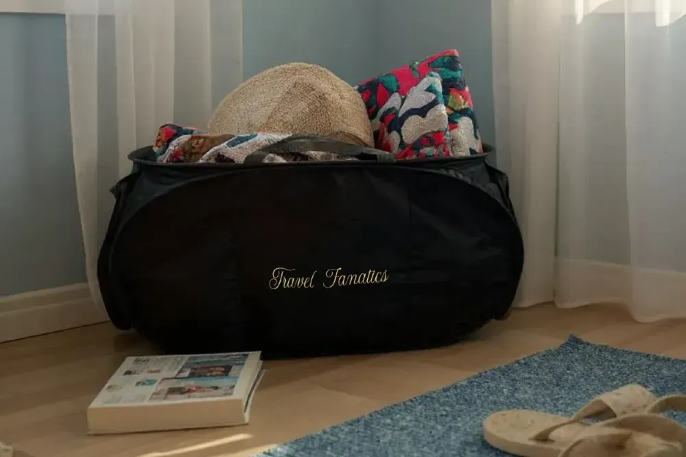 Travel Fanatics Collapsible Laundry Basket filled with clothes, demonstrating its spacious 23.5 x 12.5-inch capacity for large loads.
