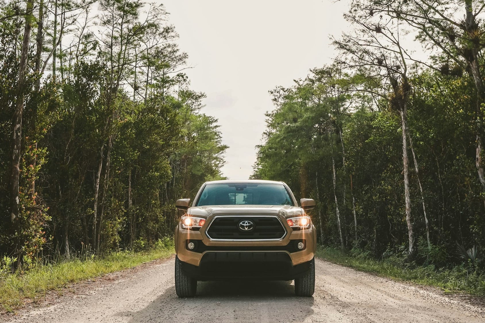 a truck is driving down a dirt road